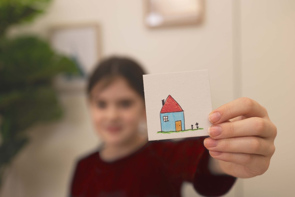 Ein Mädchen hält ein selbst bemaltes Puzzleteil hoch